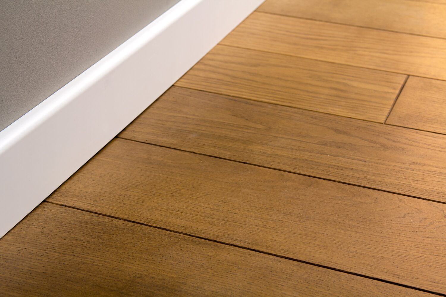 Close up of white plastic plinths on dark wooden oak floor parquet
