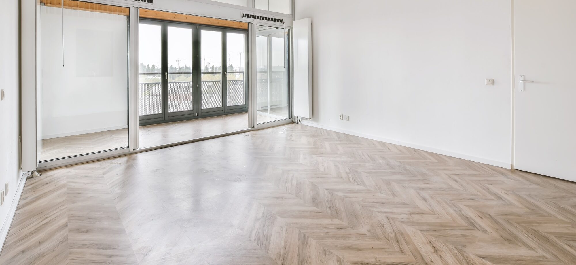 Room with large windows and parquet floor