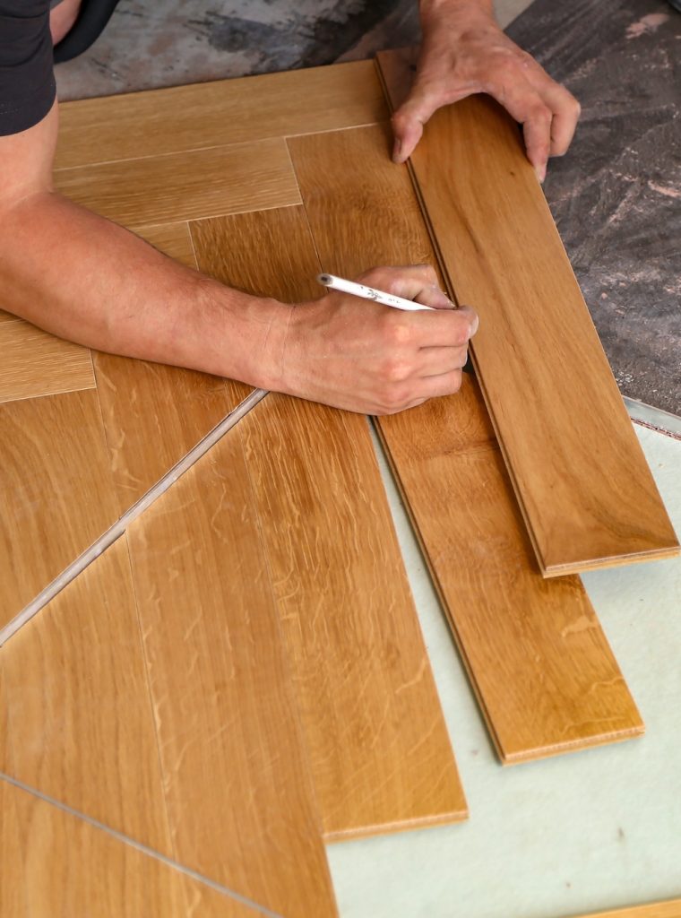 Worker installing wooden laminate flooring